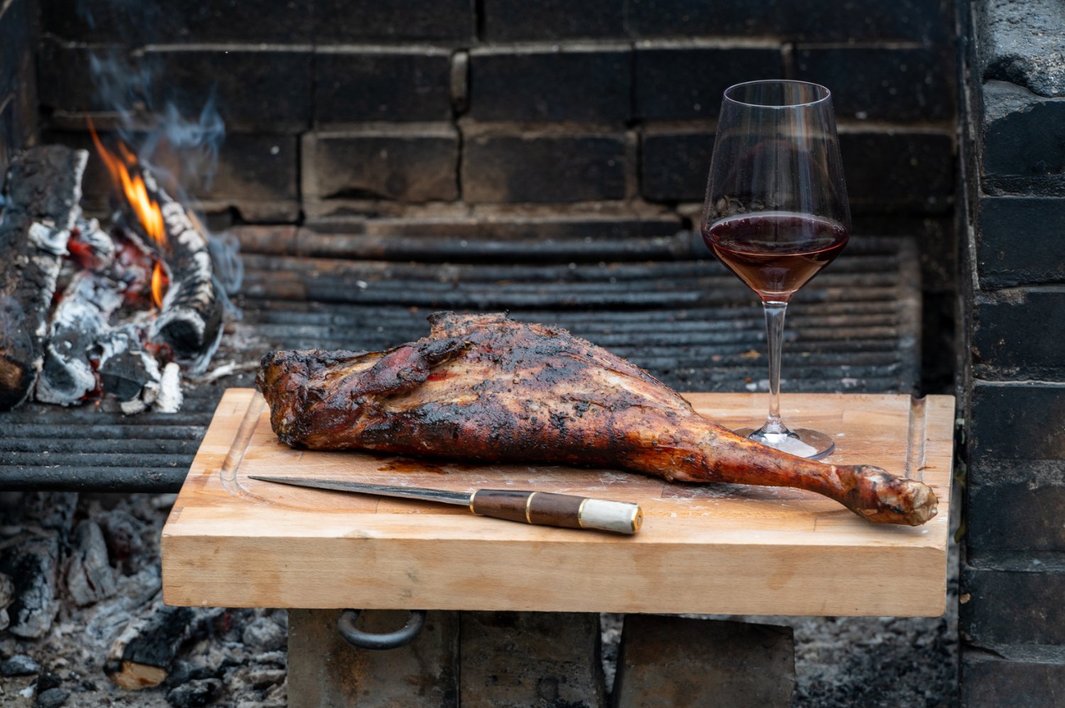 Bife con copa de vino junto al fuego